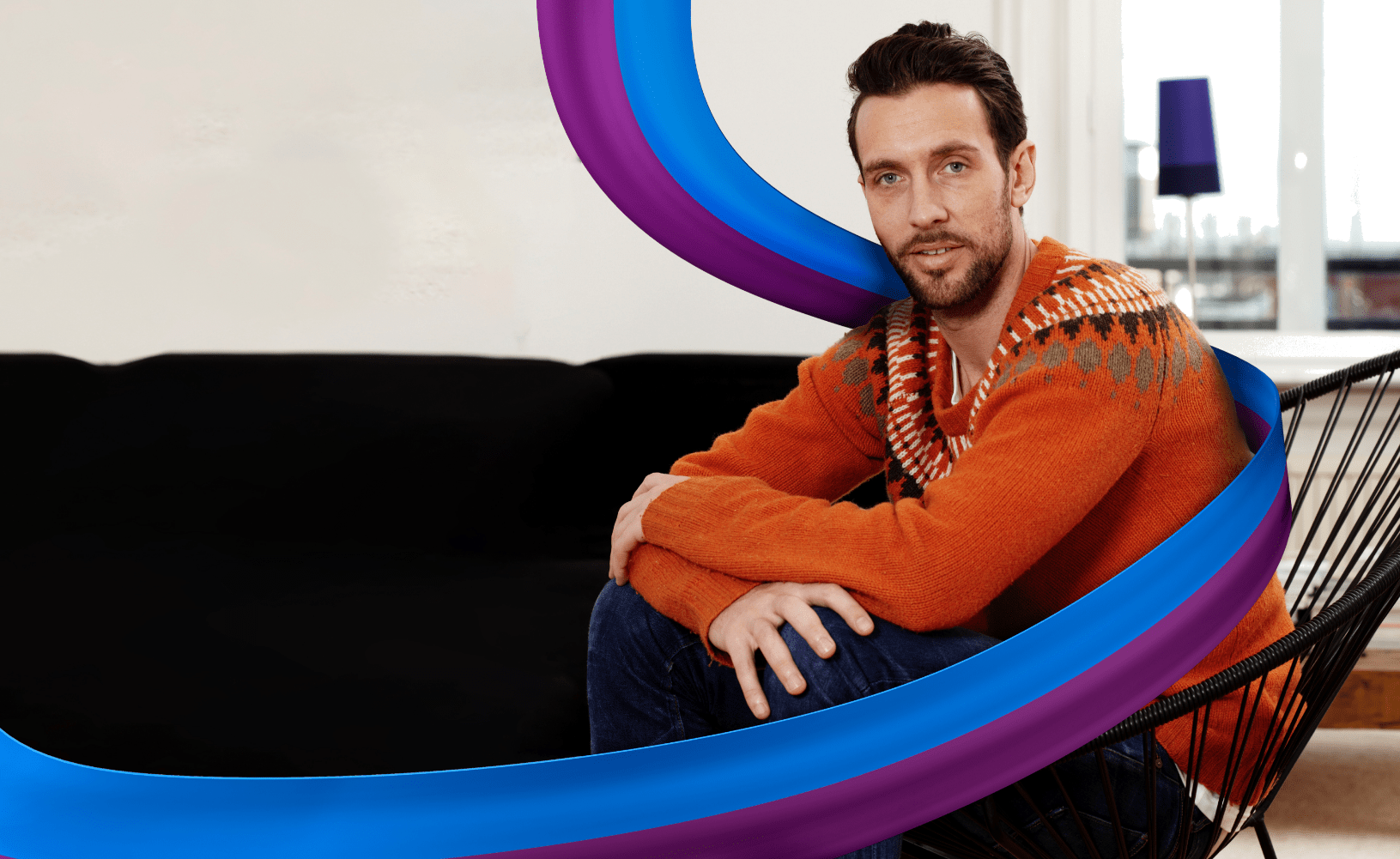 Man in orange jumper sitting on chair